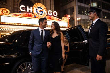 A couple exits a limousine in front of the Chicago theater.